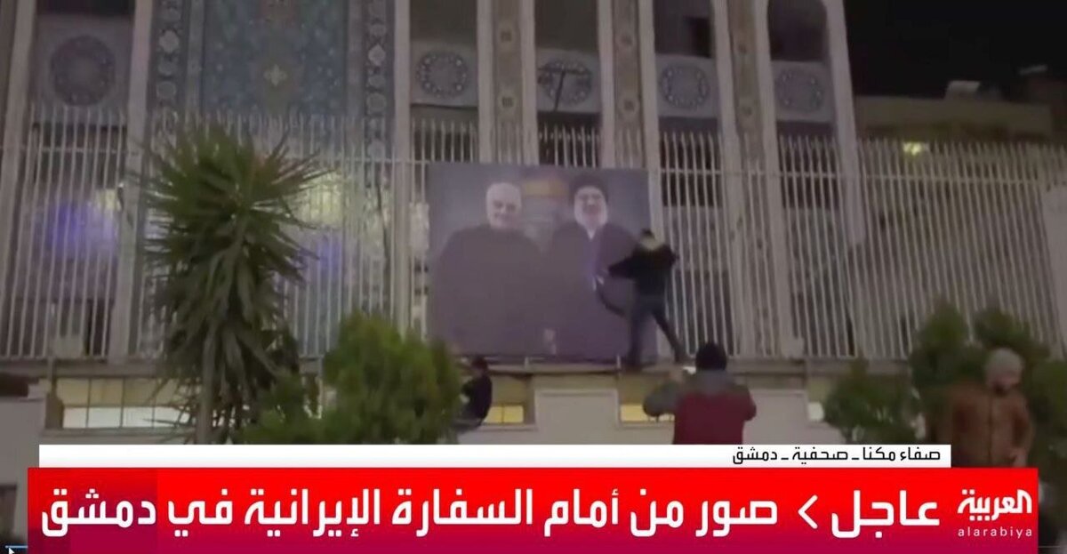 تروریست ها درحال برچیدن تصویر حاج قاسم از نمای سفارت ایران
